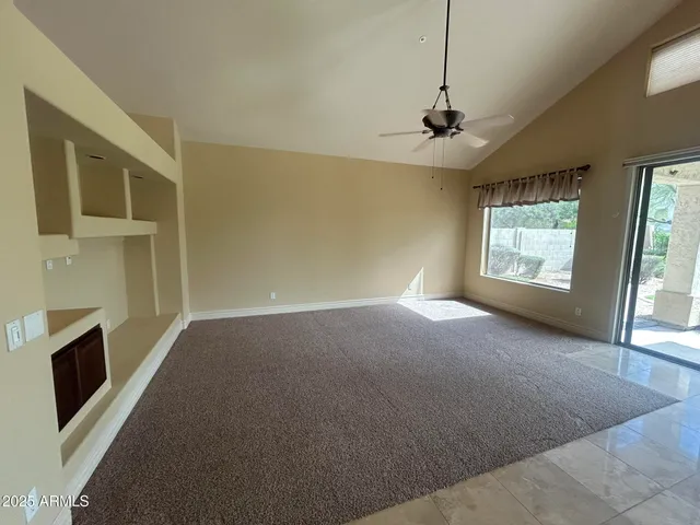a view of a livingroom with furniture chandelier flat screen tv and windows