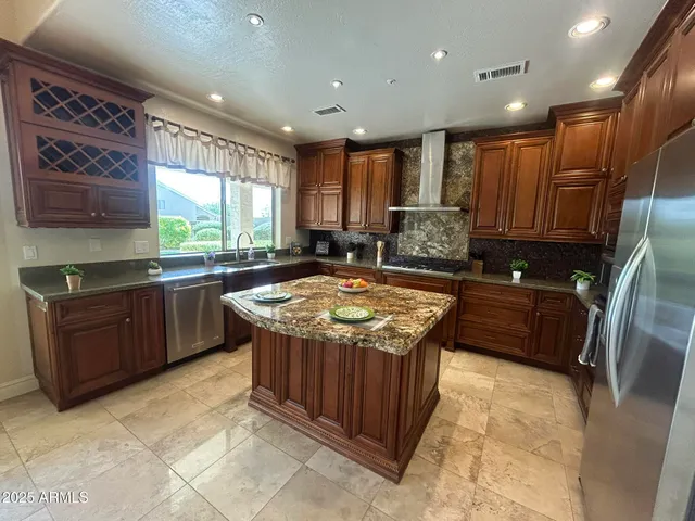 a kitchen with stainless steel appliances granite countertop a sink a stove a refrigerator a washer and dryer