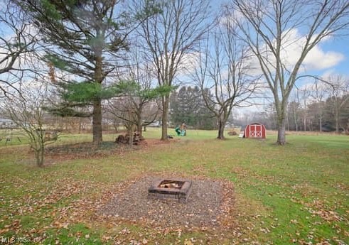 4618 South Arlington Road Uniontown, OH 44685 - Photo 19 of 31 View of yard with a storage unit and an outdoor fire pit