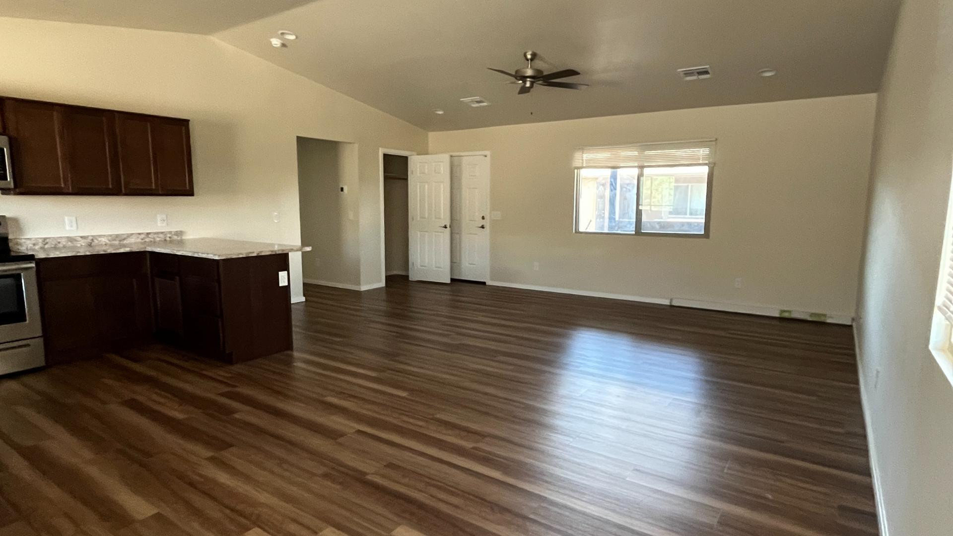 a view of a kitchen with wooden floor and a sink