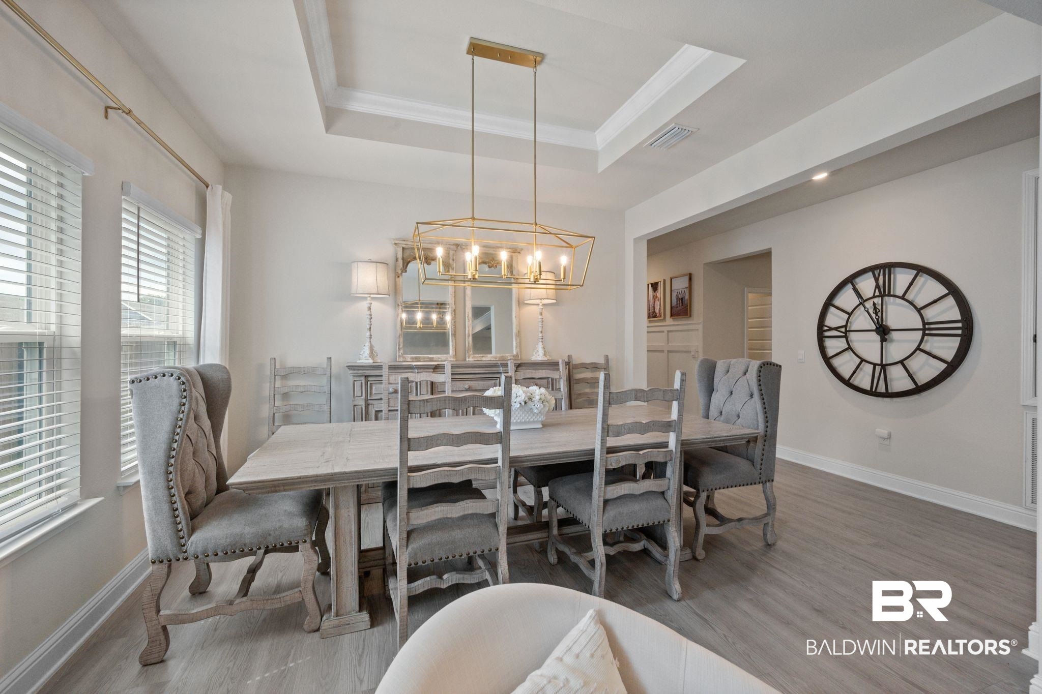 681 Calibre Street Fairhope, AL 36532 - Photo 27 of 56 Dining room featuring a raised ceiling, wood-type flooring, and an inviting chandelier