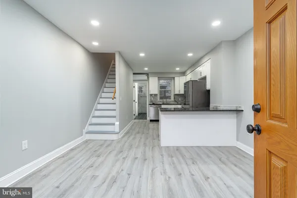 a view of a kitchen with wooden floor and staircase