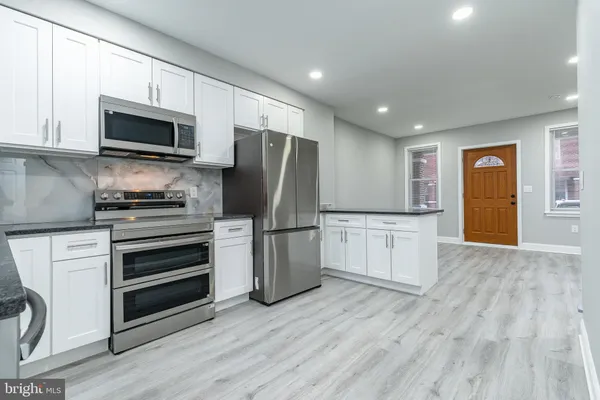 a kitchen with a refrigerator stove and wooden cabinets