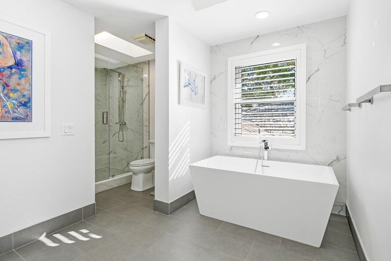 5696 Northwest 39th Avenue Boca Raton, FL 33496 - Photo 16 of 24 a spacious bathroom with a bathtub a toilet a sink and a window