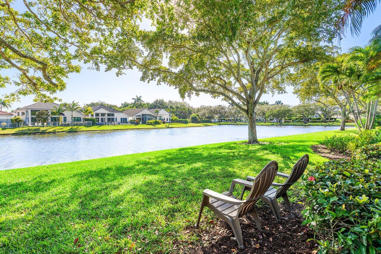 5696 Northwest 39th Avenue Boca Raton, FL 33496 - Photo 21 of 24 a view of a lake with a bench and trees