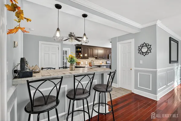 a view of a dining room and livingroom with furniture wooden floor a chandelier