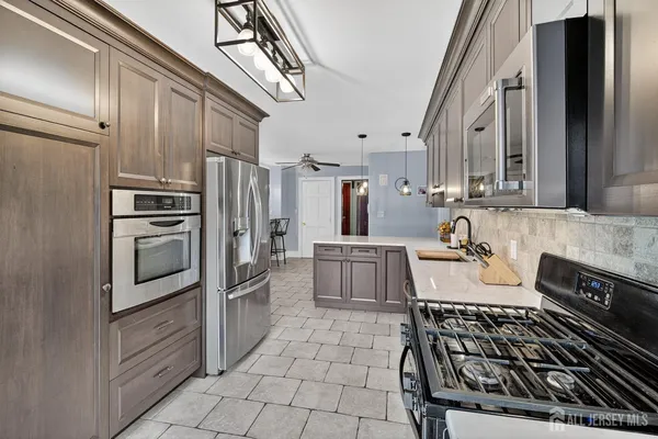 a kitchen with stainless steel appliances granite countertop a stove a sink and a refrigerator
