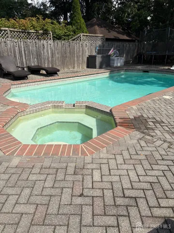 a view of a backyard with swimming pool and deck