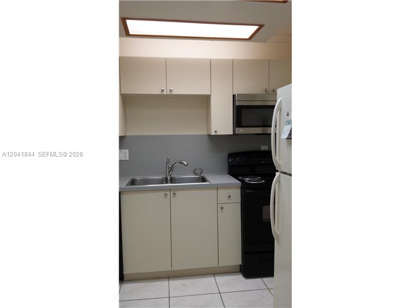 8610 Southwest 149th Avenue, Unit 504 Miami, FL 33193 - Photo 9 of 13 a kitchen with a sink and cabinets
