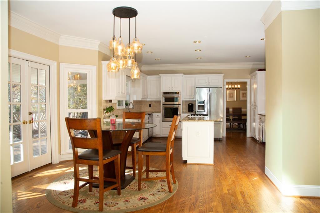 5735 Sunset Maple Drive Alpharetta, GA 30005 - Photo 19 of 39 a view of a dining room with furniture wooden floor and chandelier