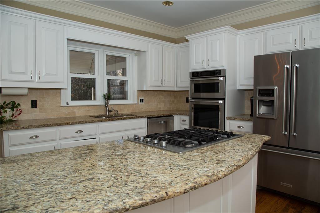 5735 Sunset Maple Drive Alpharetta, GA 30005 - Photo 21 of 39 a kitchen with stainless steel appliances granite countertop a sink stove and refrigerator
