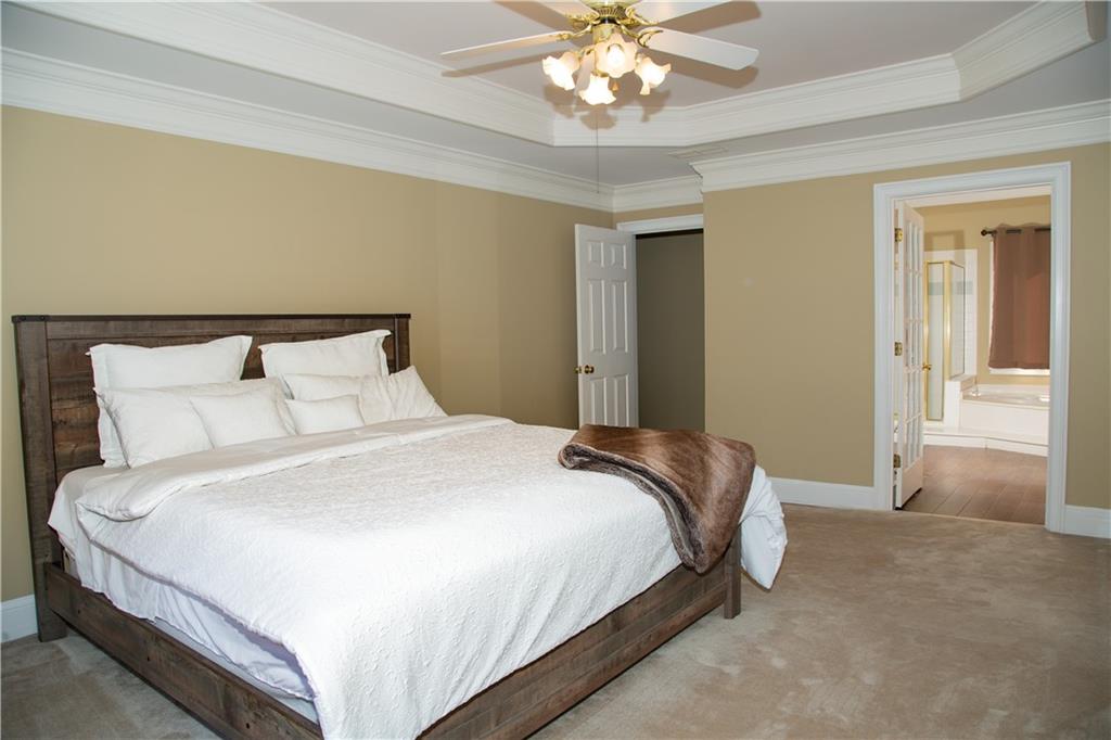 5735 Sunset Maple Drive Alpharetta, GA 30005 - Photo 23 of 39 a bedroom with bed and a chandelier