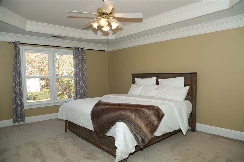 5735 Sunset Maple Drive Alpharetta, GA 30005 - Photo 24 of 39 a bedroom with a bed lamp and a large window