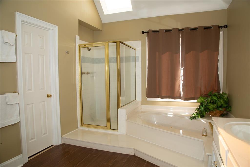 5735 Sunset Maple Drive Alpharetta, GA 30005 - Photo 26 of 39 a view of a bathroom with a shower and a tub