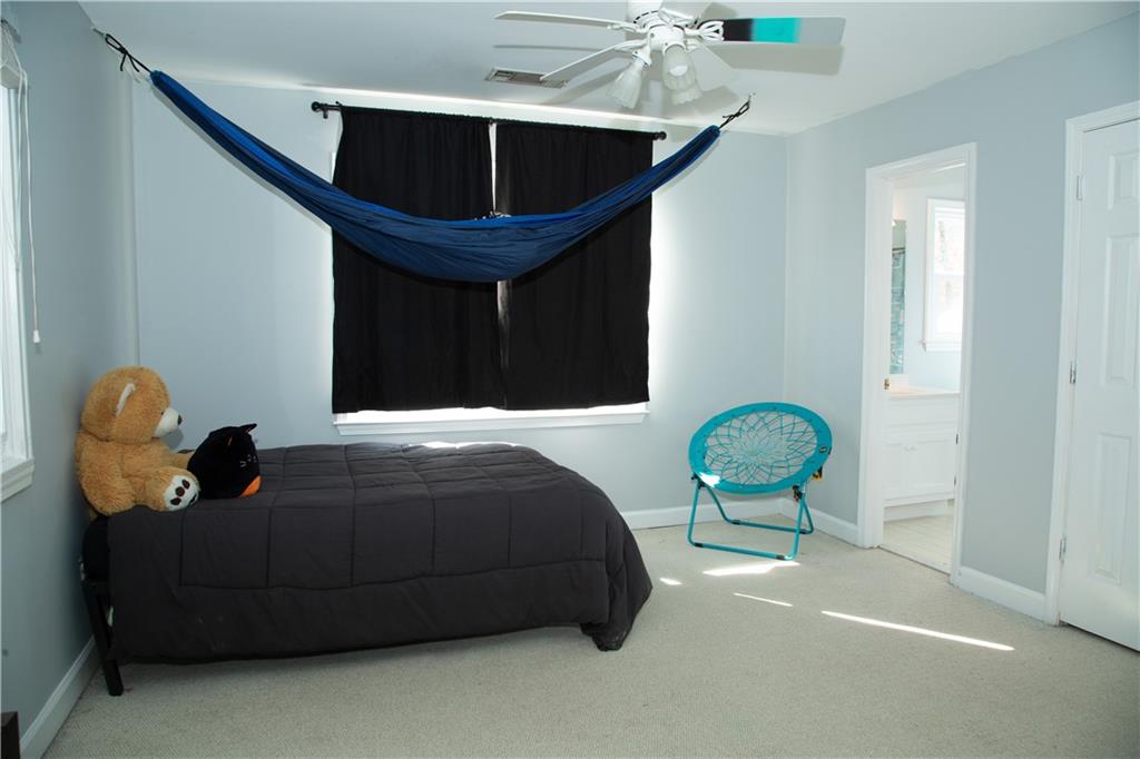 5735 Sunset Maple Drive Alpharetta, GA 30005 - Photo 29 of 39 a bedroom with a bed and a chandelier