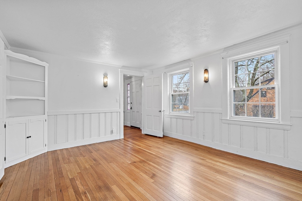 106 Lewis Avenue Walpole, MA 02081 - Photo 13 of 36 a view of an empty room with wooden floor and windows
