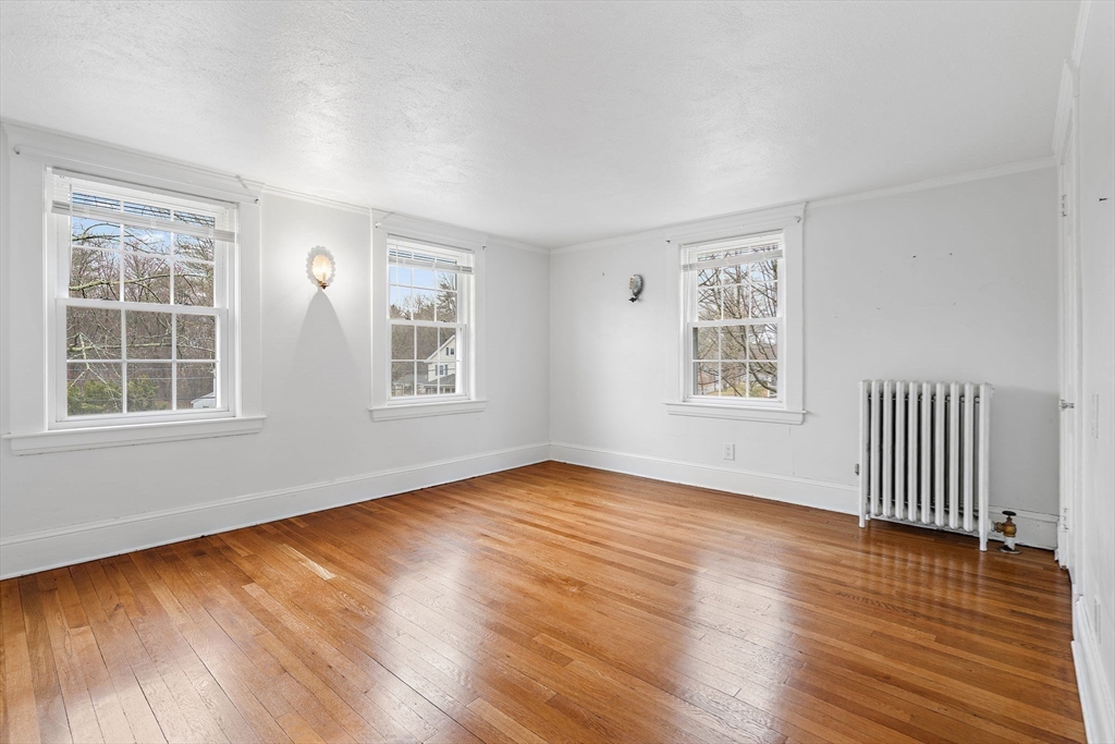 106 Lewis Avenue Walpole, MA 02081 - Photo 22 of 36 a view of an empty room with wooden floor and a window