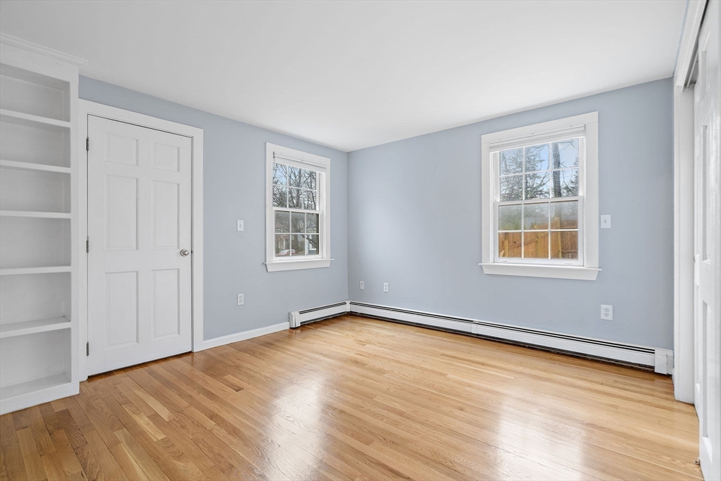 106 Lewis Avenue Walpole, MA 02081 - Photo 24 of 36 a view of an empty room with wooden floor and a window