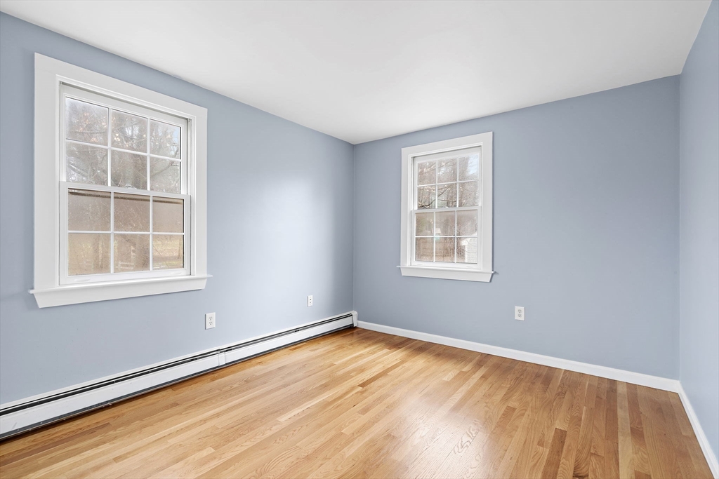 106 Lewis Avenue Walpole, MA 02081 - Photo 27 of 36 a view of an empty room with wooden floor and a window
