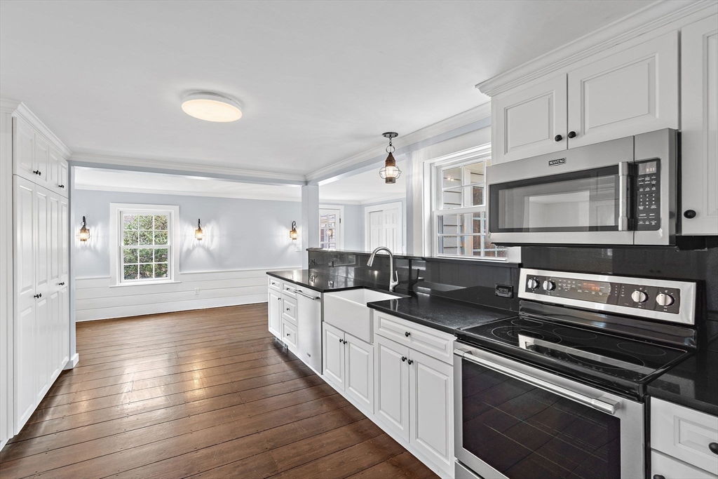 106 Lewis Avenue Walpole, MA 02081 - Photo 5 of 36 a kitchen with stainless steel appliances a stove microwave and cabinets