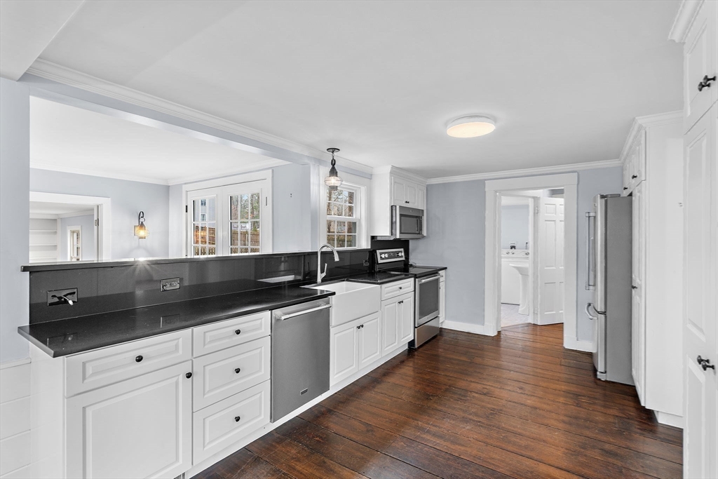 106 Lewis Avenue Walpole, MA 02081 - Photo 6 of 36 a large white kitchen with a refrigerator a sink dishwasher and white cabinets with wooden floor