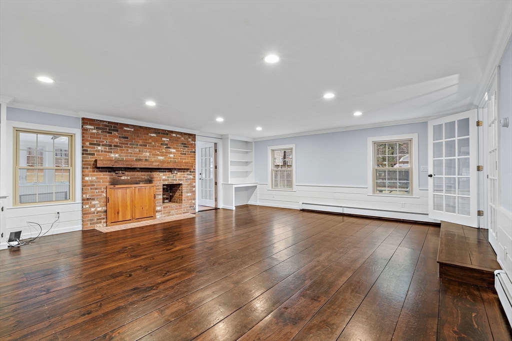 106 Lewis Avenue Walpole, MA 02081 - Photo 9 of 36 a view of an empty room with a window and wooden floor
