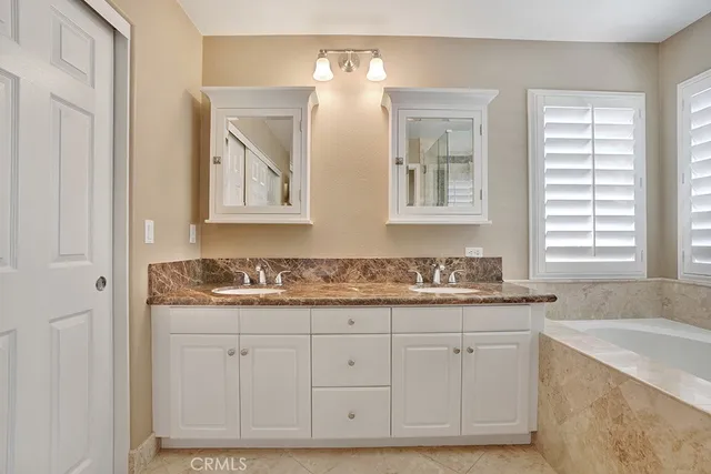 a bathroom with a granite countertop tub sink shower and mirror