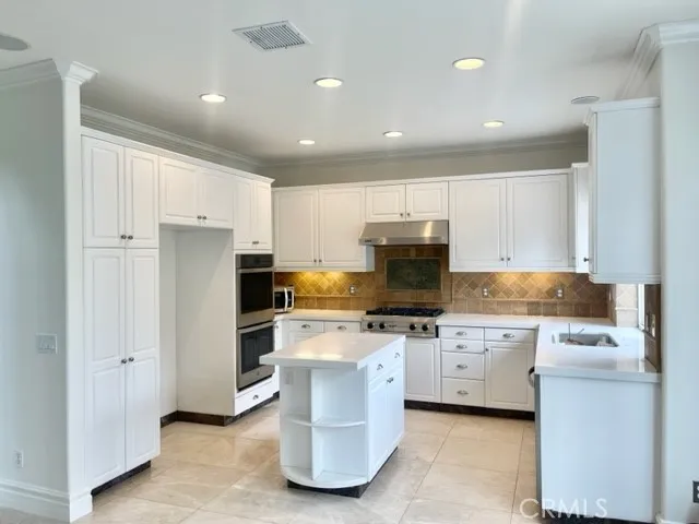 a kitchen with white cabinets and appliances