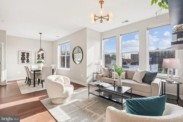 a living room with furniture a large window and a dining table