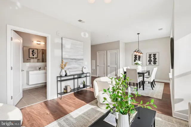 a living room with furniture potted plant and open kitchen view
