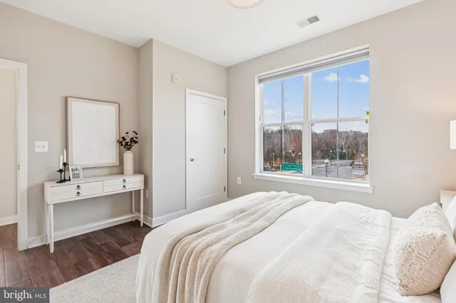 a bedroom with a bed and a large window