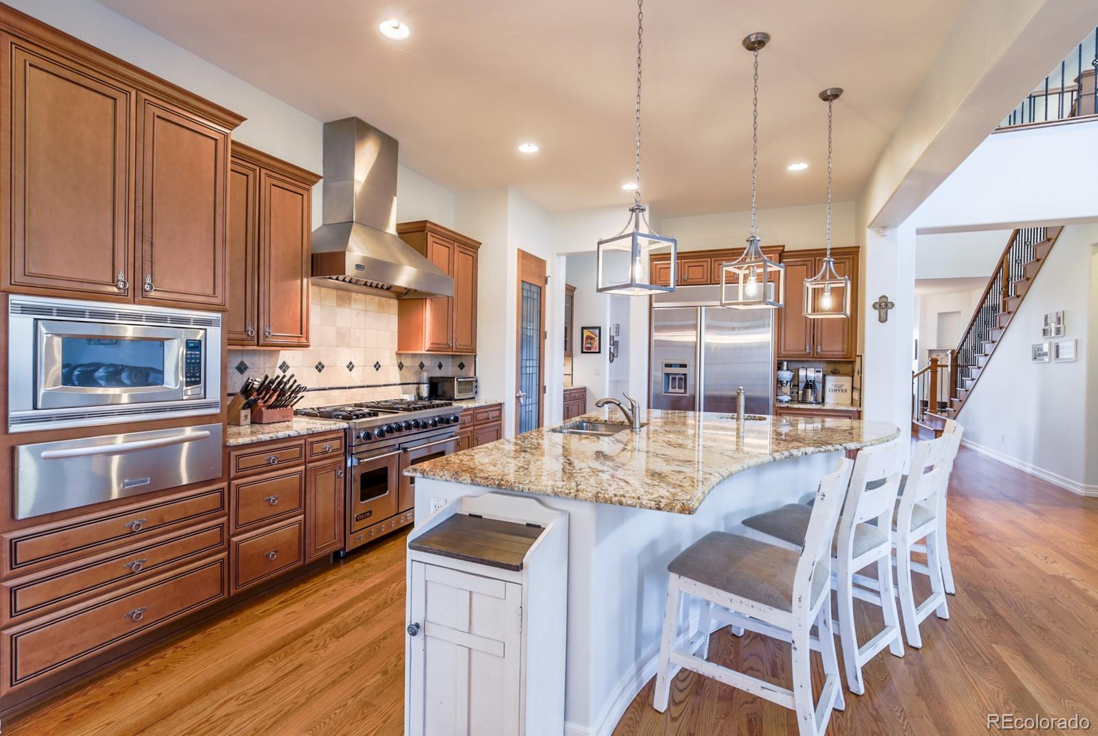 2322 Spruce Way Denver, CO 80238 - Photo 13 of 40 a kitchen with stainless steel appliances granite countertop a stove top oven a refrigerator a sink and dishwasher with wooden floor
