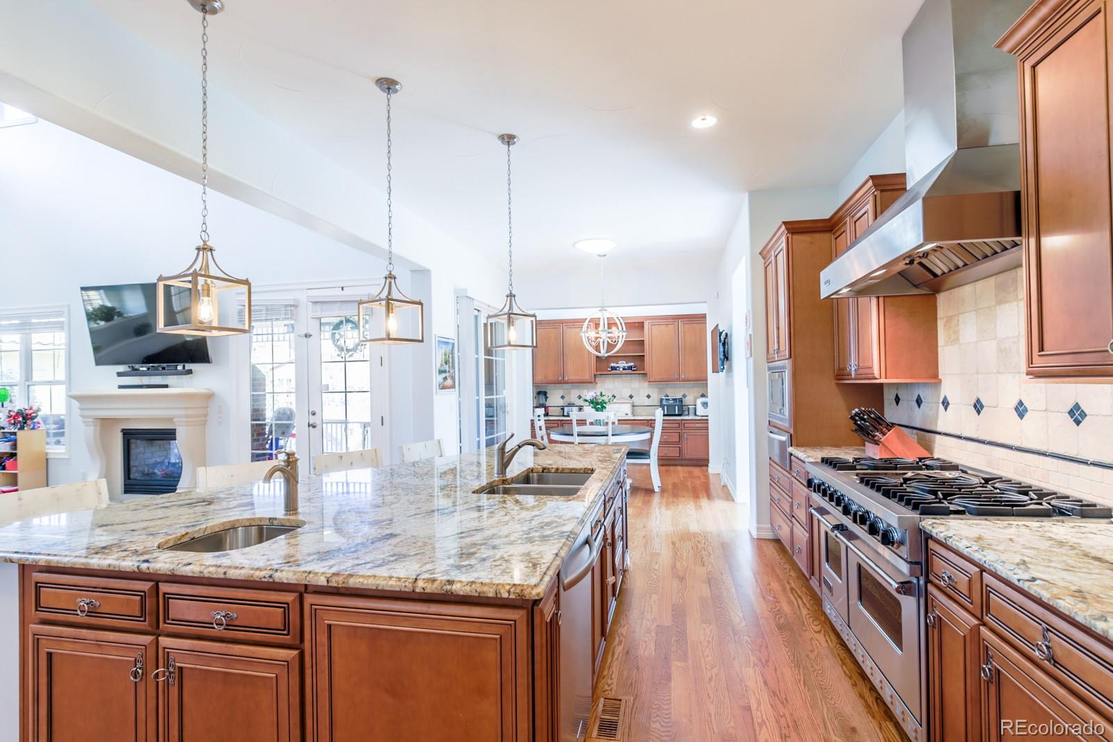 2322 Spruce Way Denver, CO 80238 - Photo 14 of 40 a kitchen with stainless steel appliances kitchen island granite countertop a stove a sink and a wooden floors