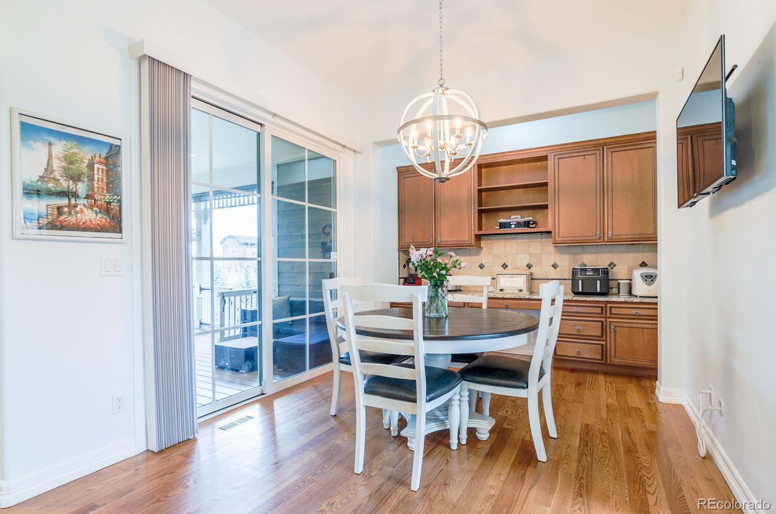 2322 Spruce Way Denver, CO 80238 - Photo 16 of 40 a view of a dining room with furniture a chandelier and wooden floor