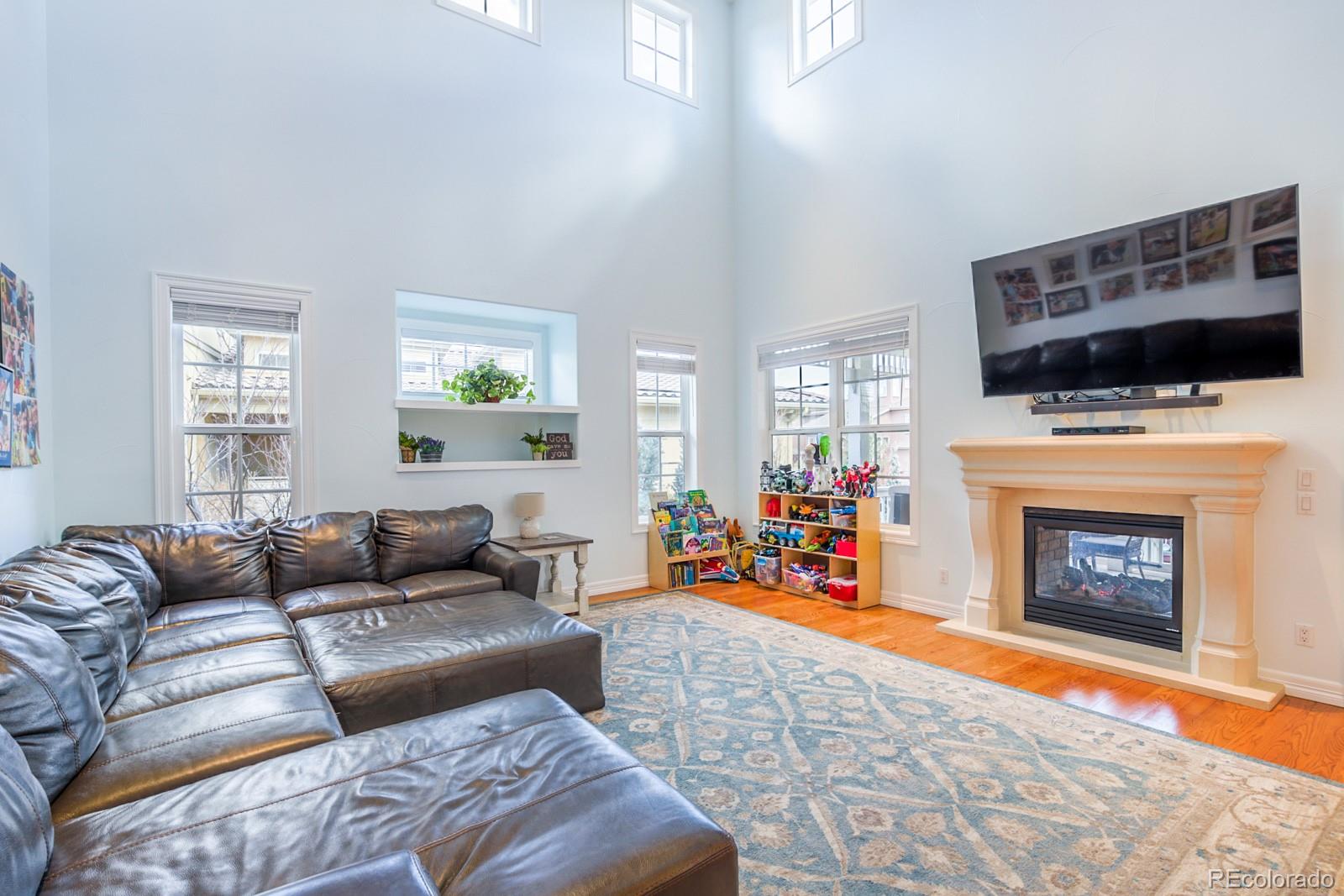 2322 Spruce Way Denver, CO 80238 - Photo 18 of 40 a living room with furniture a flat screen tv and a fireplace