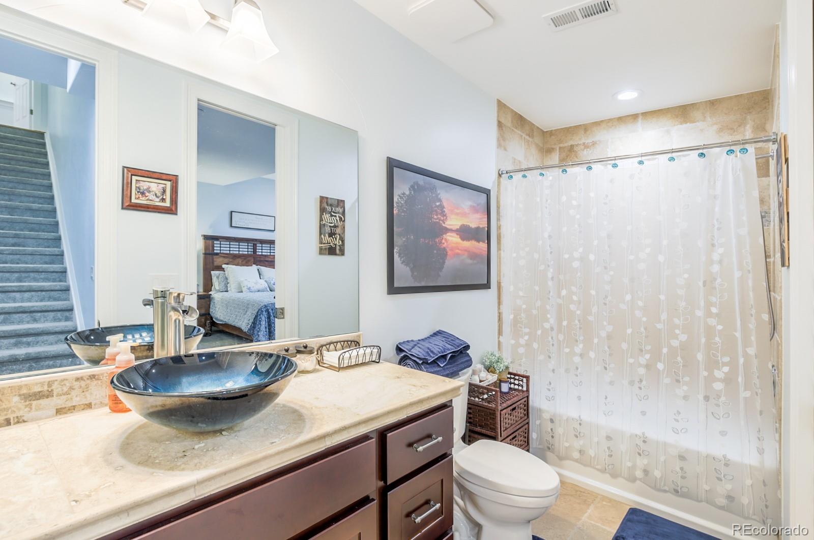 2322 Spruce Way Denver, CO 80238 - Photo 37 of 40 a bathroom with a granite countertop sink a toilet a mirror and shower