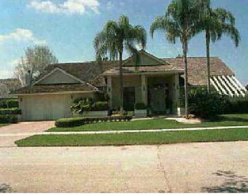 4413 Woodfield Boulevard Boca Raton, FL 33434 - Photo 2 of 2 a view of a house with a yard and palm trees