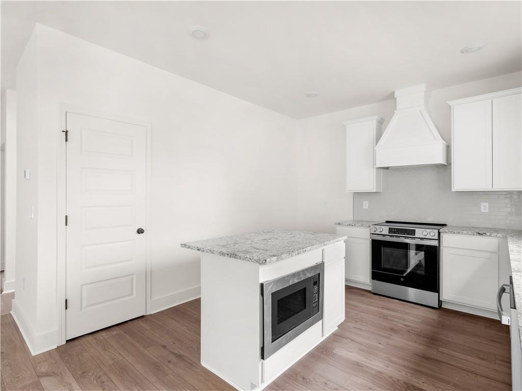 200 Loyd Road Mansfield, GA 30055 - Photo 12 of 54 a kitchen with granite countertop white cabinets and stainless steel appliances