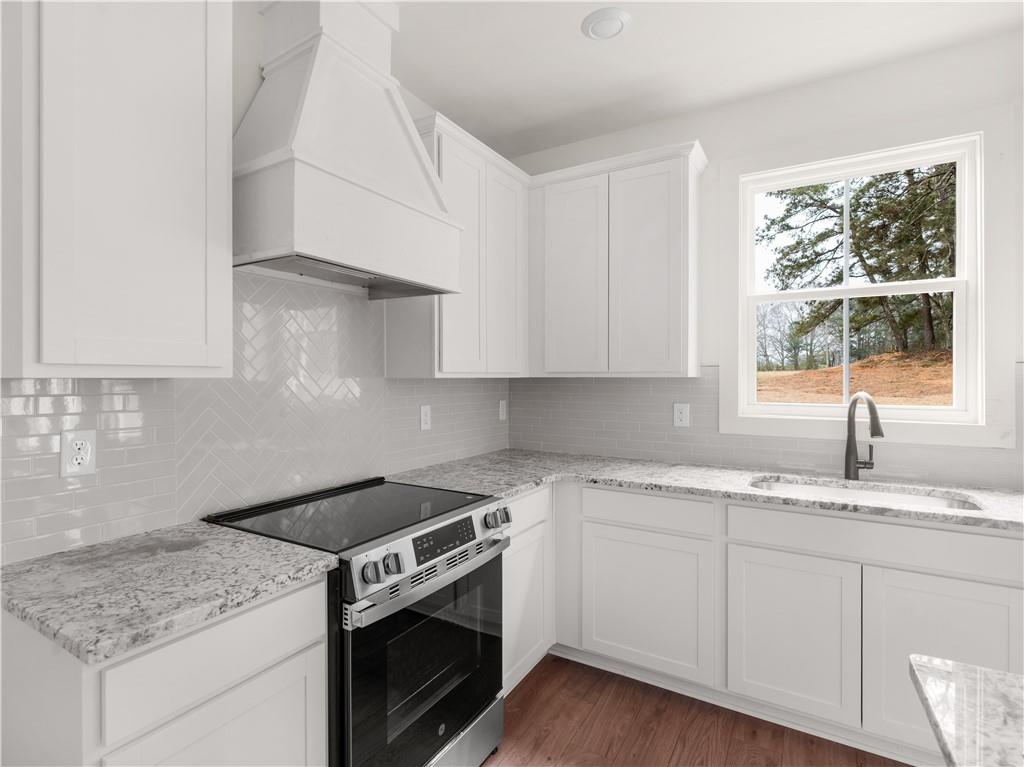 200 Loyd Road Mansfield, GA 30055 - Photo 17 of 54 a kitchen with granite countertop stainless steel appliances white cabinets granite counter tops and a wooden floors