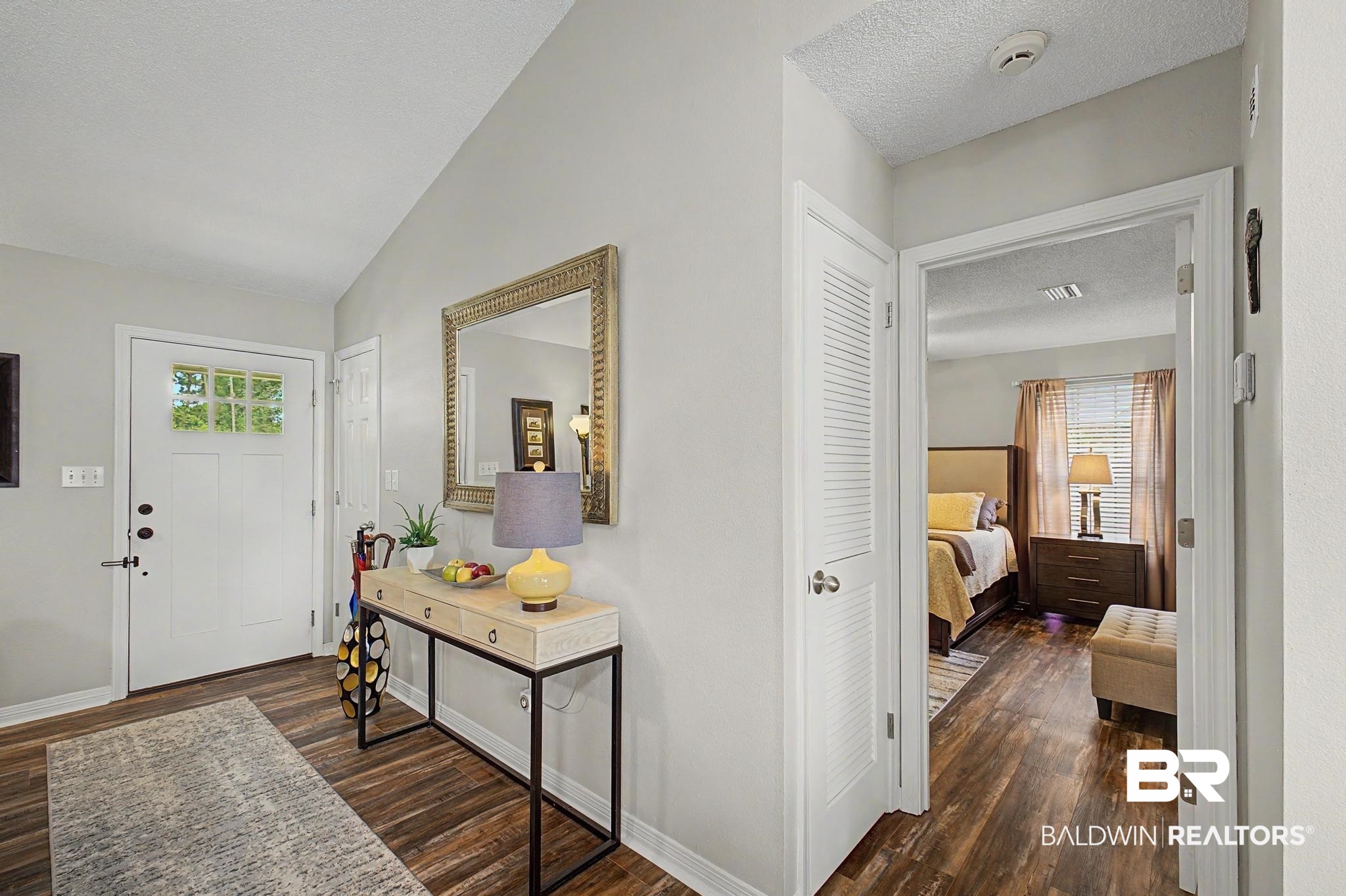 2808 Pine Ridge Drive Lillian, AL 36549 - Photo 6 of 47 Entryway featuring wood-finish flooring, a white paneled front door with decorative glass inserts, and light grey wall tones