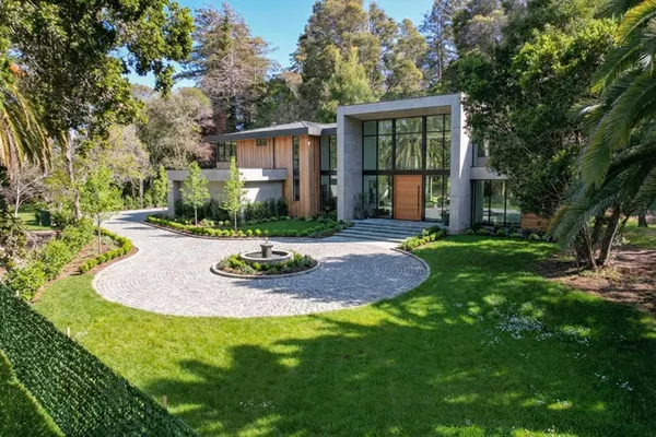 a view of a house with backyard and sitting area