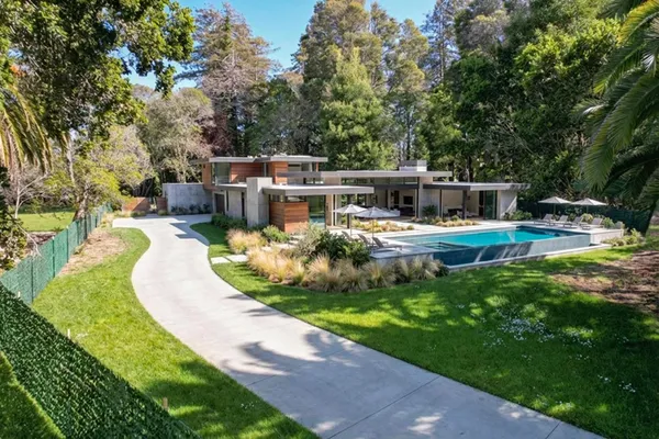 an aerial view of a house with a garden and trees