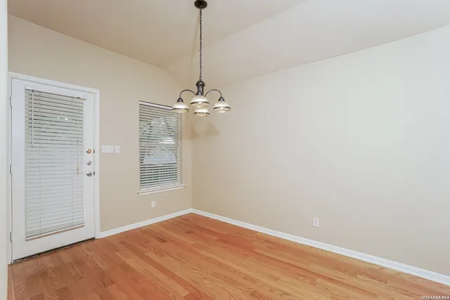 a view of empty room with wooden floor and ceiling fan