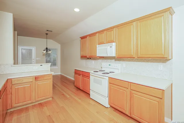 a kitchen with stainless steel appliances granite countertop a sink and cabinets with wooden floor