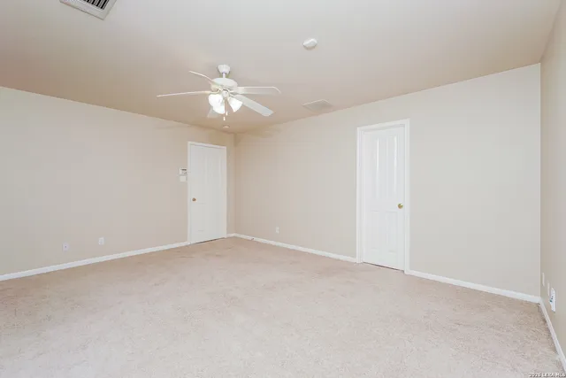 an empty room with a ceiling fan and a window