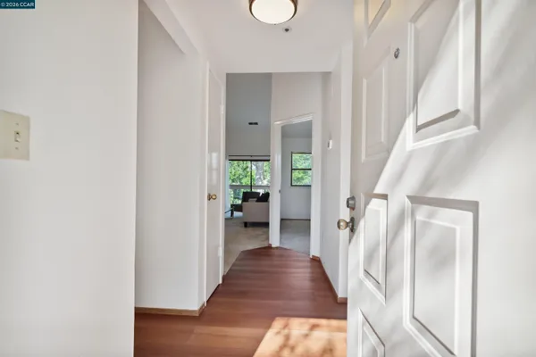 a view of a hallway with wooden floor and staircase