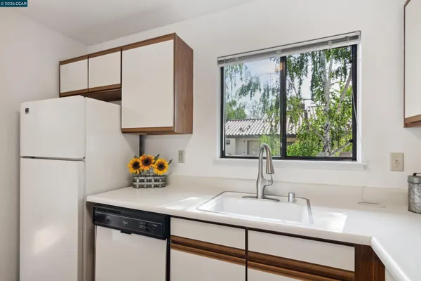 a kitchen with stainless steel appliances a sink a refrigerator and a window