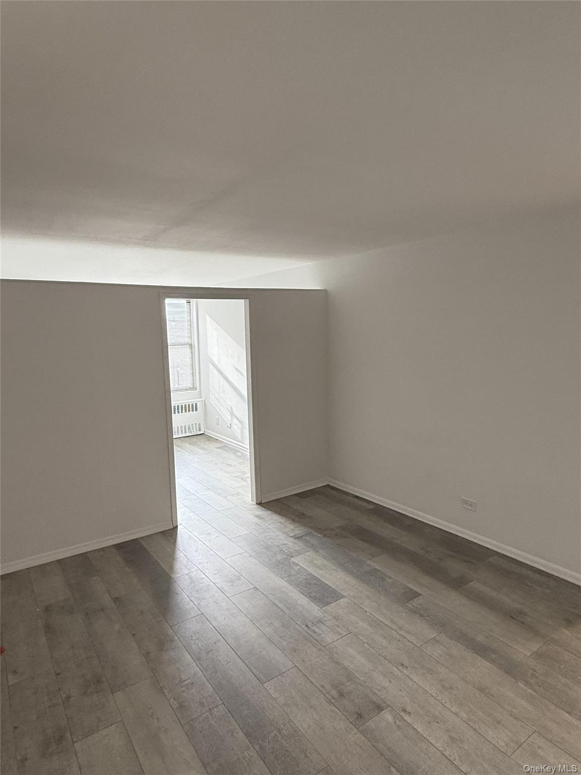 83-30 Vietor Avenue, Unit 727 Queens, NY 11373 - Photo 3 of 11 an empty room with wooden floor and windows