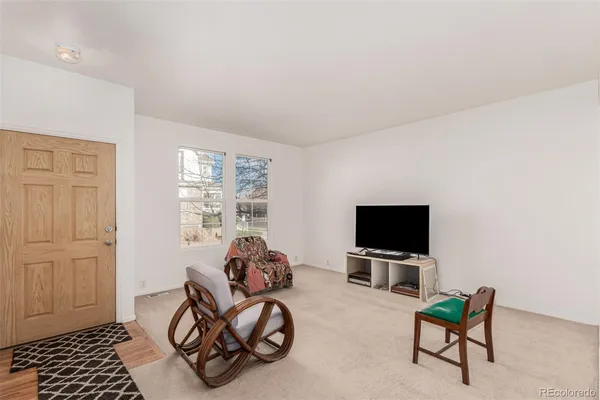 a living room with furniture a flat screen tv and a window