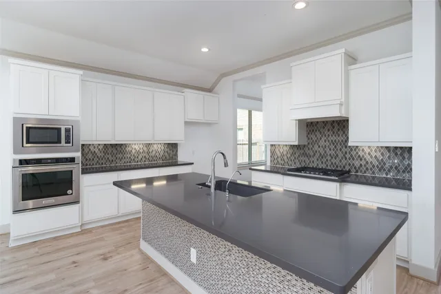 a kitchen with kitchen island granite countertop a sink a counter top space and cabinets